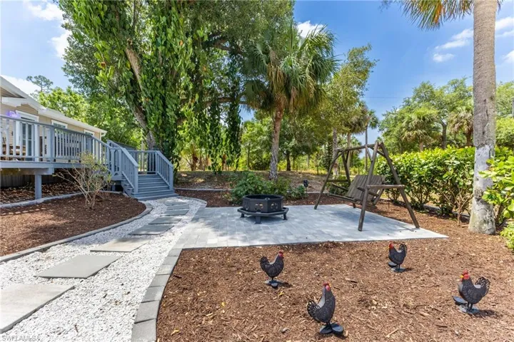 View of yard featuring an outdoor fire pit, a wooden deck, a patio, and stairway