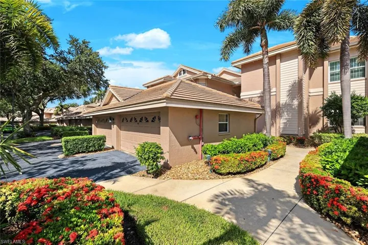 Charming front entry surrounded by lush landscaping.