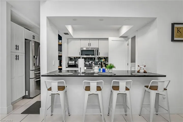 Newly Remodeled Kitchen with Stainless Steel Appliances, Stainless Steel Sink with One Handle Pull Down Faucet, White Shaker Cabinetry with Matte Black Pulls, Black Quartz Counters, Open Shelving & Recessed Lighting