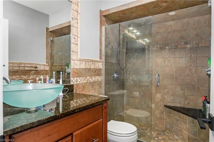 Third Bathroom with Floor to Ceiling Tile, Glass Shower Enclosure and Bench Seating, Wood Vanity with Glass Vessel Sink, and New Upgraded Hardware