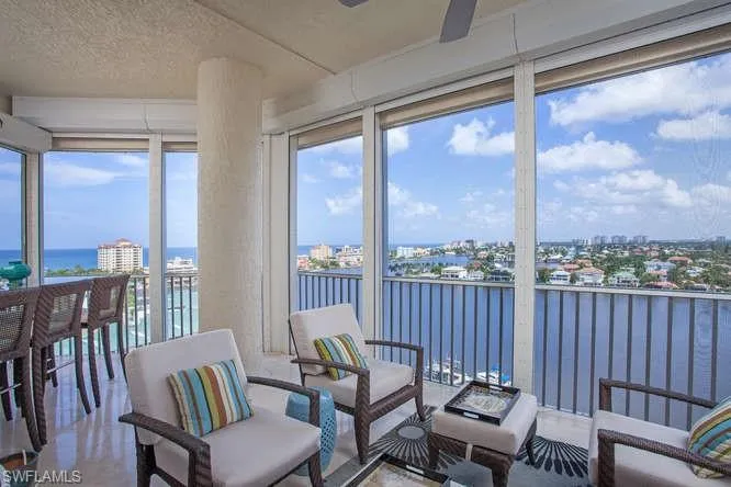 Sunroom / solarium featuring a water view, a textured ceiling, and a view of city