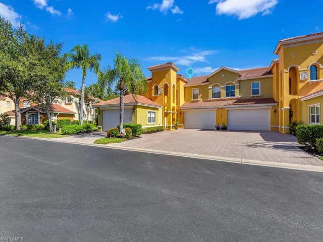 Mediterranean / spanish-style home with a tile roof, stucco siding, decorative driveway, an attached garage, and a residential view