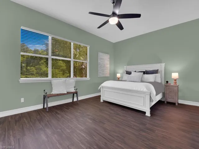 Bedroom with dark wood-style flooring and ceiling fan