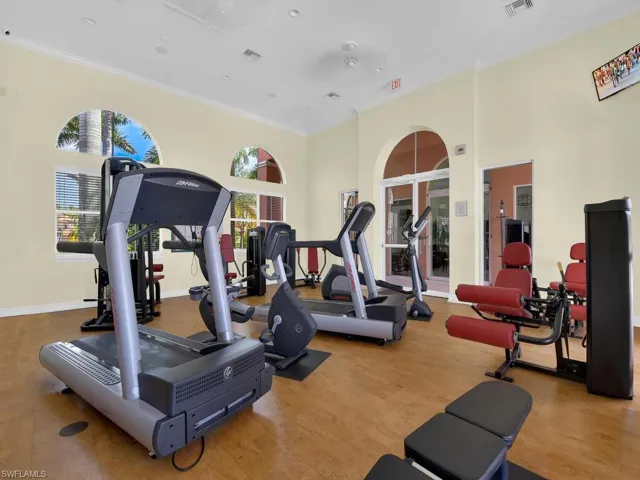 Workout area featuring ornamental molding and a high ceiling