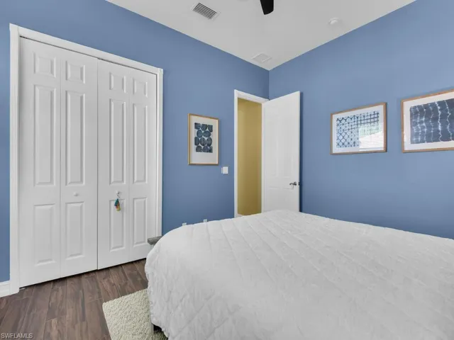 Bedroom featuring dark wood finished floors, a closet, and a ceiling fan