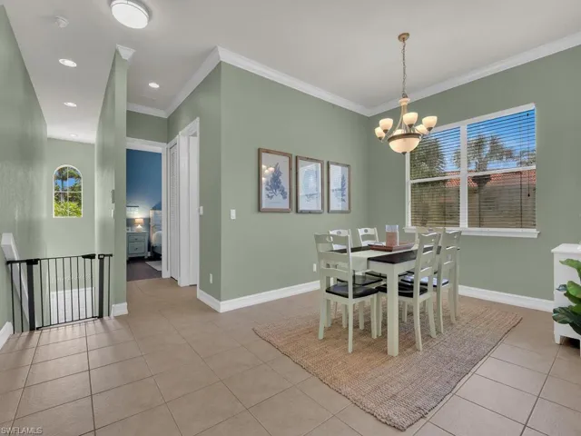 Dining room with crown molding, light tile patterned floors, a chandelier, and recessed lighting