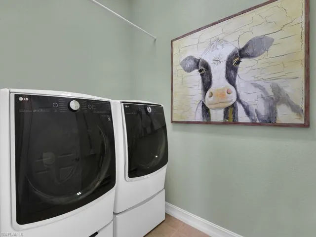 Washroom featuring separate washer and dryer and tile patterned flooring