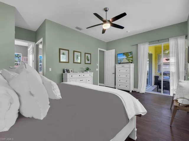 Bedroom featuring access to exterior, dark wood finished floors, and a ceiling fan