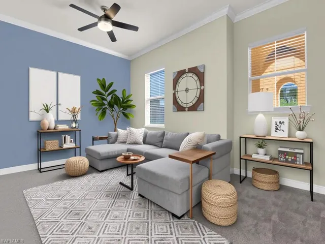 Carpeted living area featuring crown molding and a ceiling fan