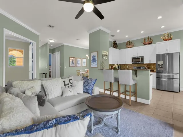 Living area featuring light tile patterned flooring, recessed lighting, crown molding, and a ceiling fan