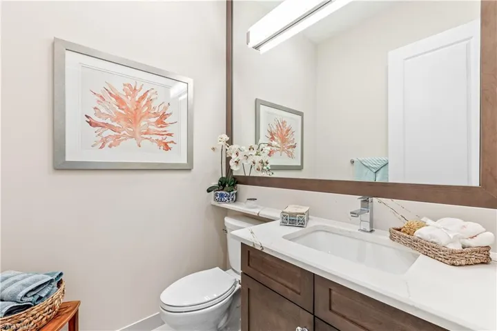 Guest powder room adorned with customframed mirror.