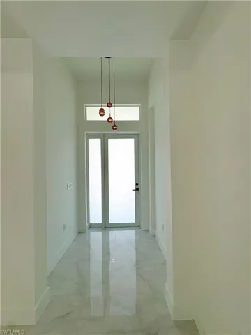 Empty room featuring marble look tile flooring and a tray ceiling