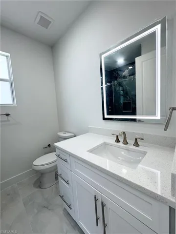 Spare room featuring a raised ceiling, light marble finish flooring, and recessed lighting