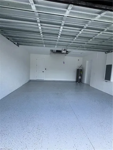Garage featuring electric panel and water heater