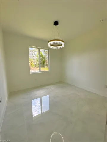 Doorway to outside featuring light marble finish floors and baseboards