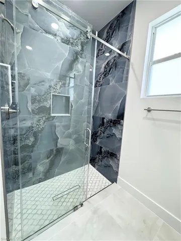 Hall with a barn door and light marble finish floors