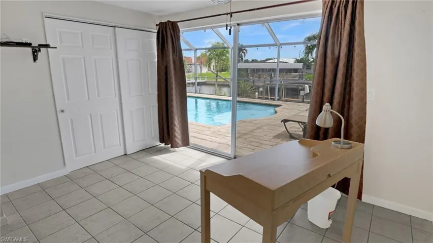 View of pool with a sunroom and a water view