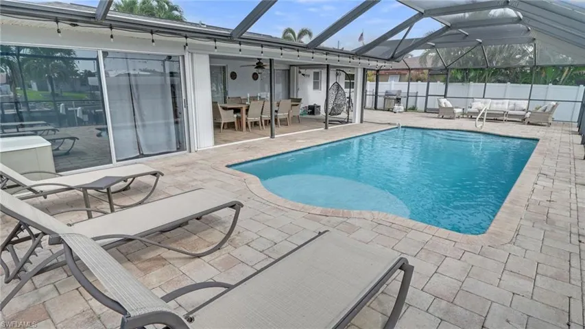 View of swimming pool with an outdoor living space, a sunroom, a patio, glass enclosure, and outdoor dining space