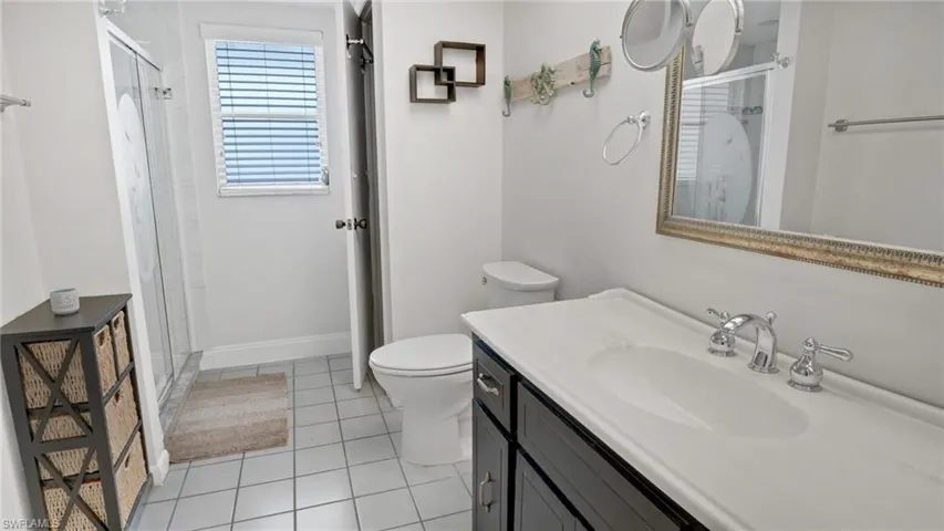 Full bathroom featuring a shower stall, vanity, and light tile patterned floors