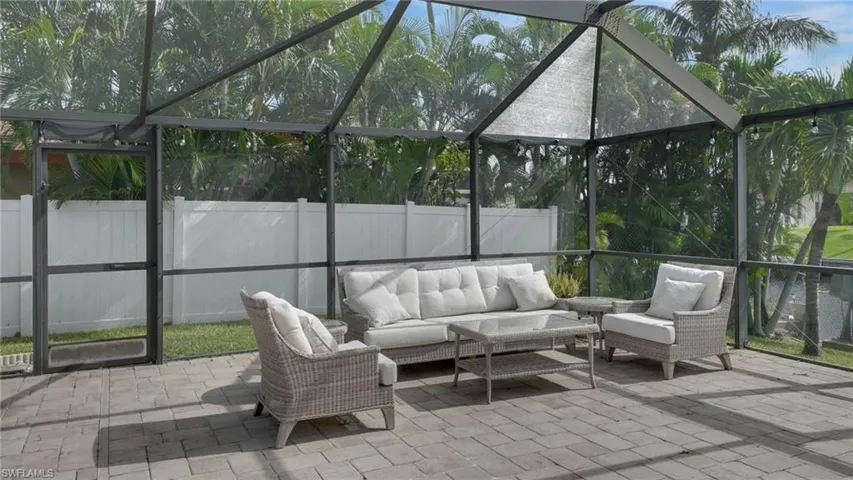 Fenced backyard with a lanai, a sunroom, and outdoor lounge area