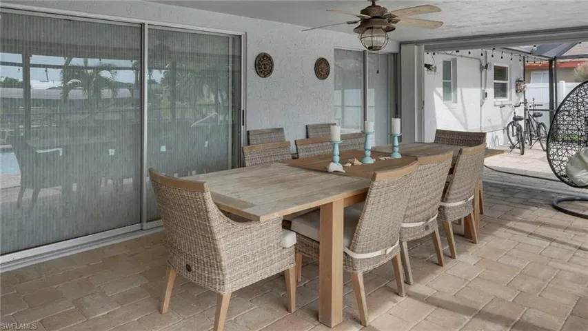 View of patio with outdoor dining area and ceiling fan