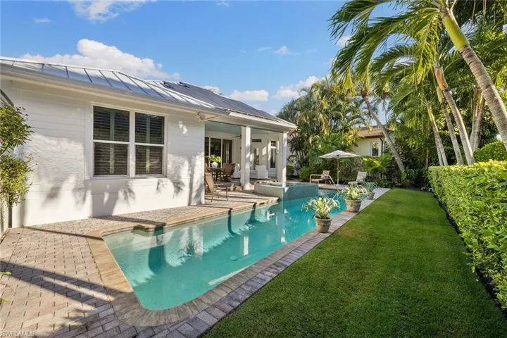 Swimming pool featuring a patio and a lawn