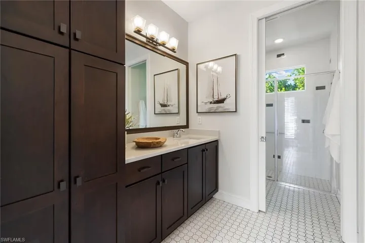Full bathroom with vanity, a stall shower, and light tile patterned floors