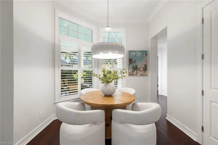 Dining room featuring dark wood-style floors and ornamental molding
