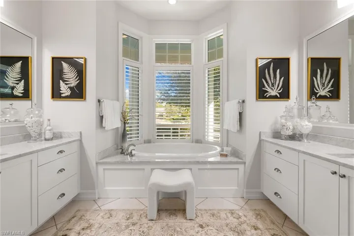 Bathroom featuring a garden tub, vanity, and light tile patterned flooring