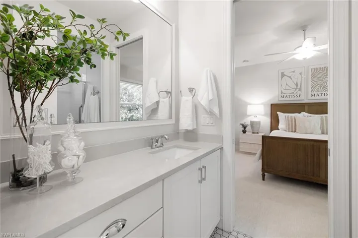 Bathroom featuring ensuite bathroom, a ceiling fan, light carpet, and vanity