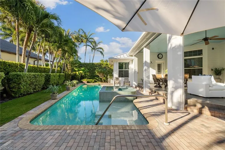 View of pool with a patio area, ceiling fan, and outdoor dining space