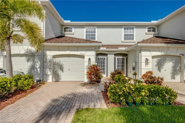 View of front of property with a garage and screened in front entry
