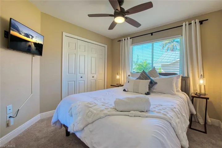 Carpeted bedroom featuring a closet and a ceiling fan