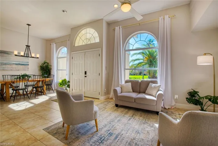 Living room with tile patterned floors, a chandelier, and a ceiling fan