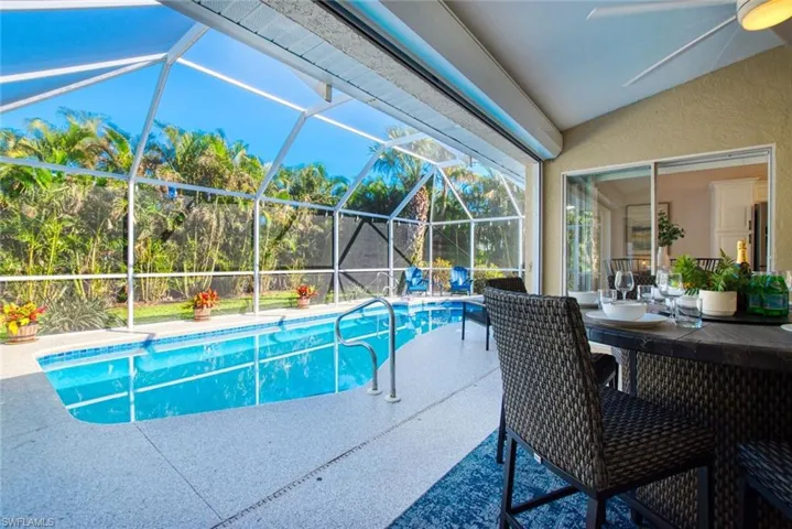 Swimming pool featuring a sunroom, a patio area, and a lanai