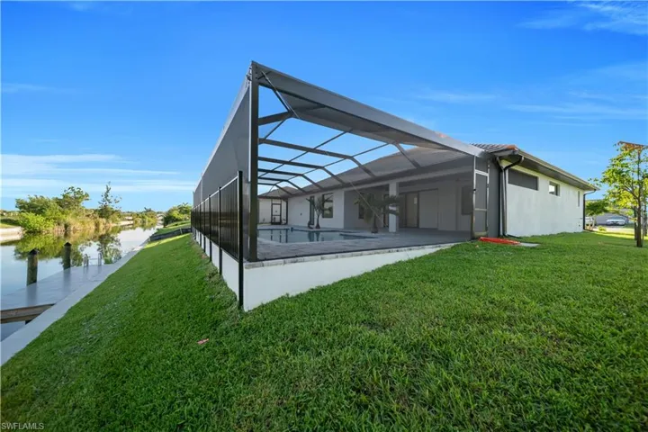 Back of house with a lawn, a lanai, and a patio area