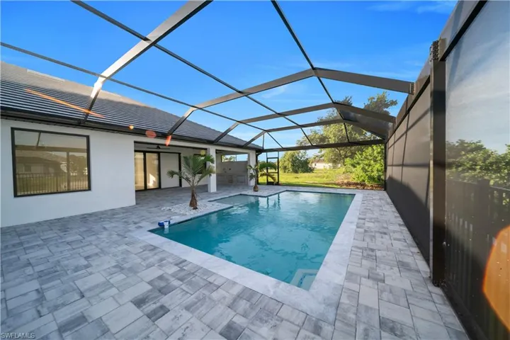 Outdoor pool with a patio, glass enclosure, and ceiling fan