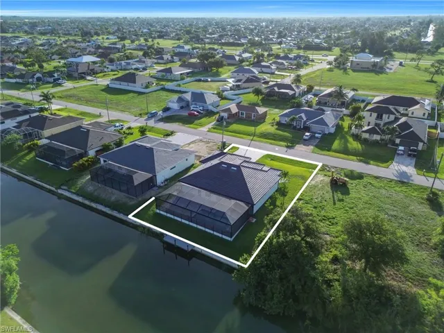 Aerial perspective of suburban area with property boundaries highlighted and a nearby body of water