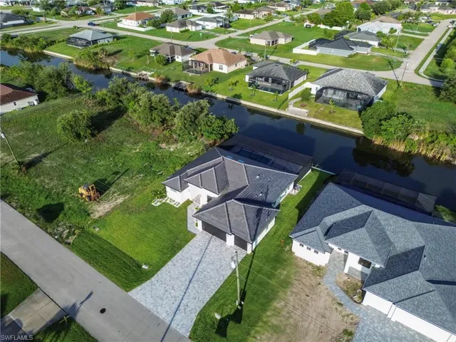 Aerial view of property and surrounding area featuring nearby suburban area