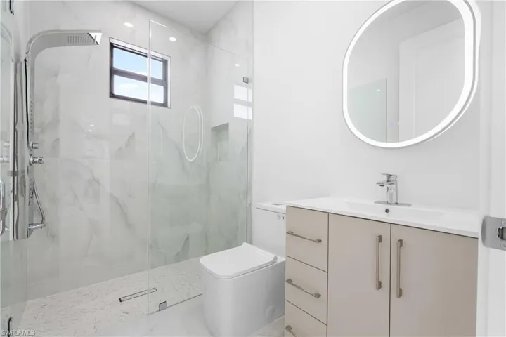 Full bathroom with vanity and a marble finish shower