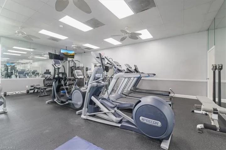 Workout area featuring a ceiling fan and a paneled ceiling