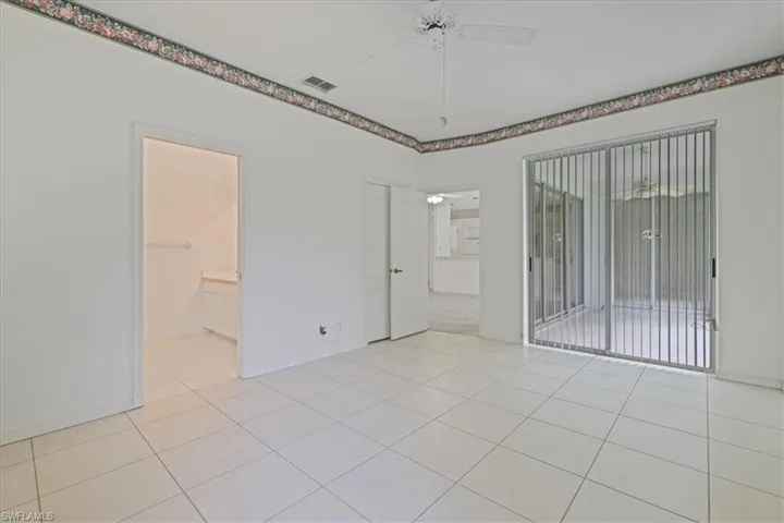 Unfurnished bedroom with light tile patterned flooring, ceiling fan, and access to exterior