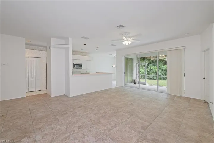 Unfurnished living room featuring ceiling fan and baseboards