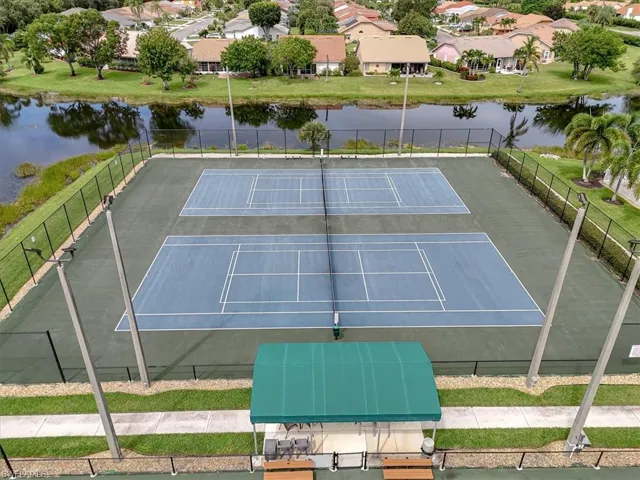 View of tennis court with a water view