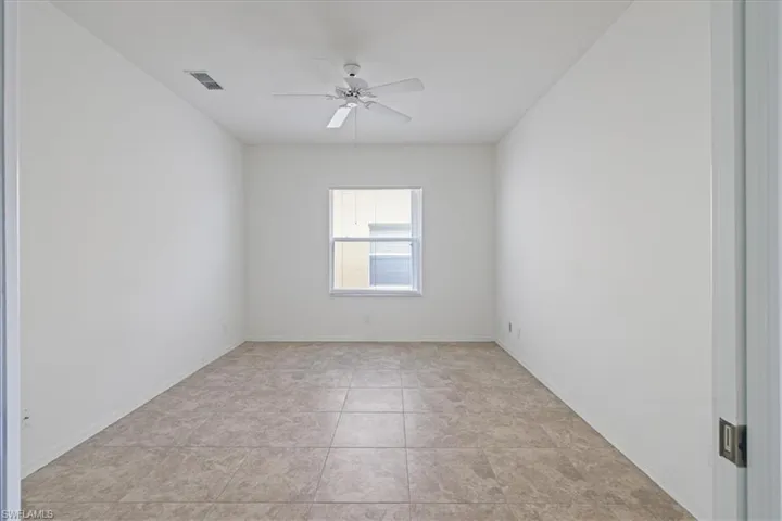 Spare room with ceiling fan and light tile patterned floors