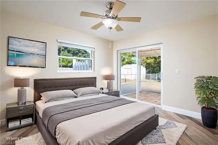 Bedroom/Office/Den with multiple windows, wood plank tile floors, ceiling fan, and newly installed slider glass door with access to outside lanai and backyard.