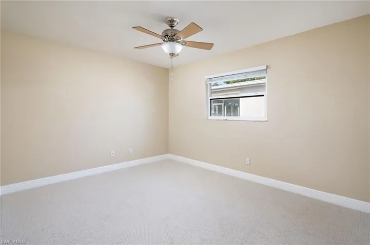 Freshly painted bedroom with new carpet flooring and ceiling fan