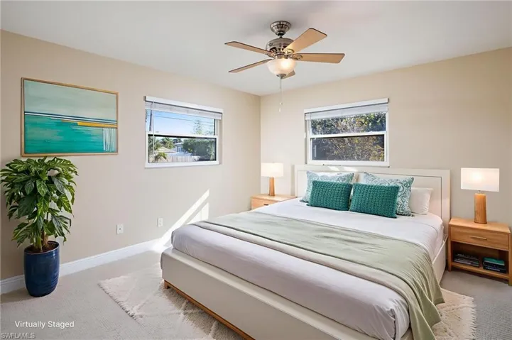 Newly carpeted and freshly painted bedroom with ceiling fan.