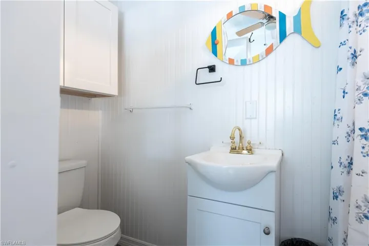 Full bath featuring vanity, a shower with curtain, and a ceiling fan