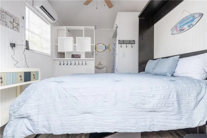 Bedroom featuring an AC wall unit and a ceiling fan